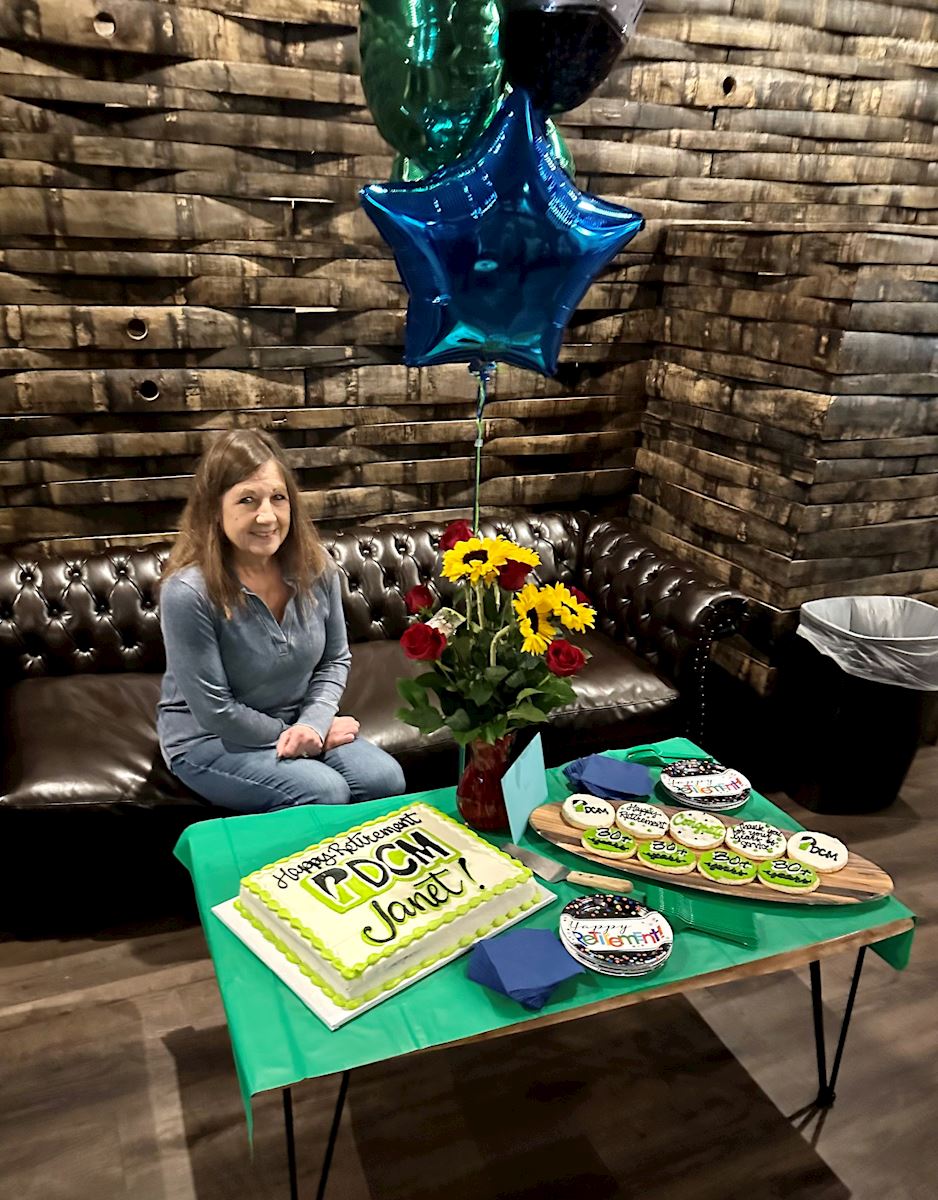 Janet Dufel celebrates retirement with cake and balloons.
